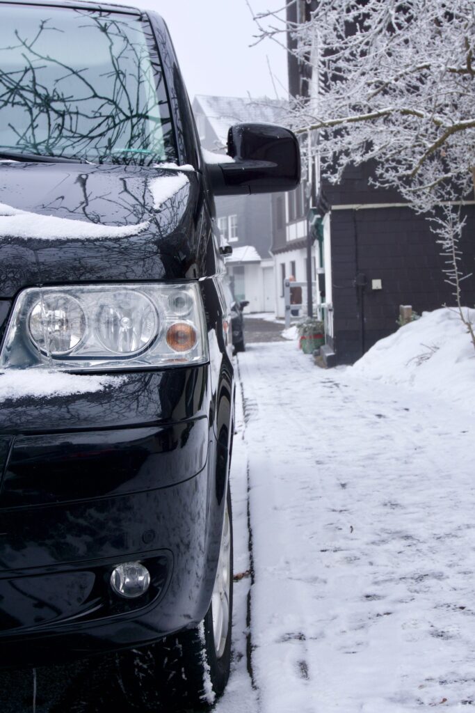 Hochformat-Foto: Kleinbus/Van parkt an Straßenrand im verschneiten Winterberg